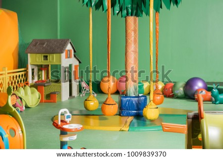 swings and colorful toys in entertainment center Royalty-Free Stock Photo #1009839370