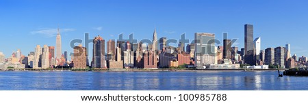 Manhattan midtown skyline panorama over East River with urban skyscrapers and blue sky in New York City
