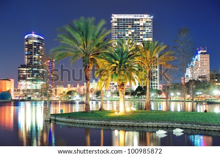Orlando downtown skyline panorama over Lake Eola at night with urban skyscrapers, tropic palm tree and clear sky. Royalty-Free Stock Photo #100985872
