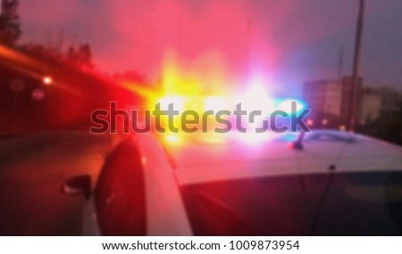 Lights of police car in evening time. Patrolling the city, crime scene. Abstract blurry image.