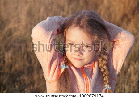 Portrait of a girl with pigtails closeup on a sunny day outdoors