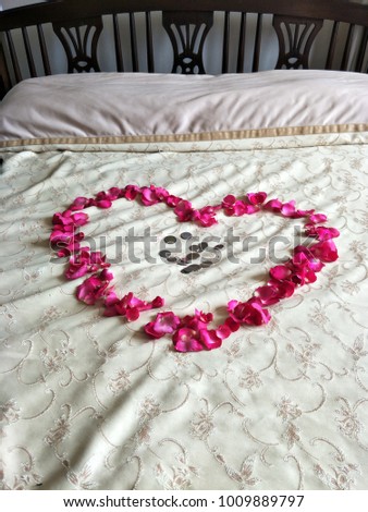 Heart shape made from rose petals with coins on the bed for wedding ceremony in Thailand

