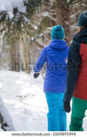 Pair of female friends snowshoeing in forest in Ontario, Canada.