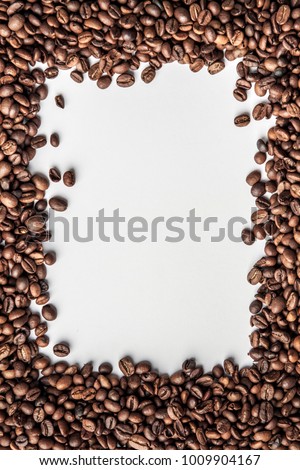 A vertical frame made of coffee in beans with a white background for the text in the middle
