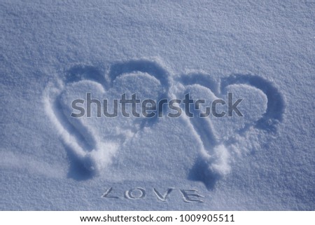 Two hearts painted on sparkling snow