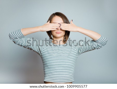 business woman covers her eyes with her hands, isolated on background, studio photo