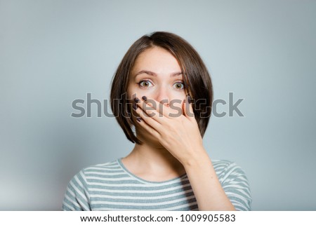 business woman covers her mouth with her hands, isolated on background, studio photo