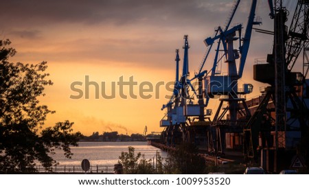 Harbor cranes in the Free port of Riga, Latvia, at beautiful baltic sunset Royalty-Free Stock Photo #1009953520