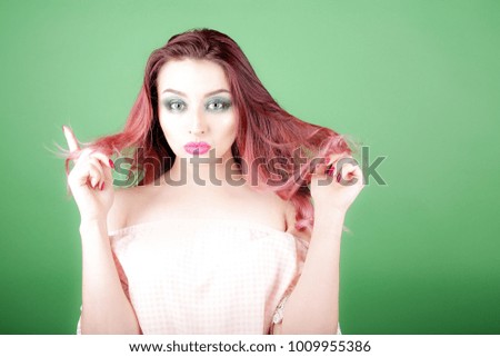 Beauty woman touch her long red hair isolated on green background, european beauty