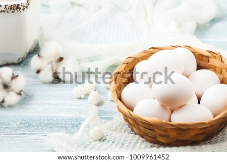 Easter white eggs in a wicker basket on a light background Background for a postcard