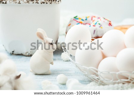 Easter white eggs and a rabbit on a light background Background for a postcard