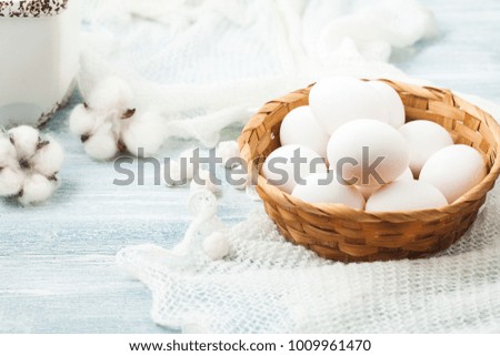 Easter white eggs in a wicker basket on a light background Background for a postcard