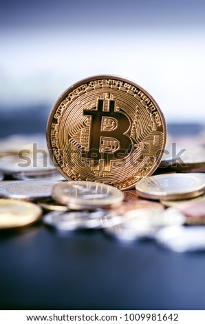 Golden bitcoin coins on a dark background with euro coins.  Virtual currency. Crypto currency. New virtual money. Lens flare 