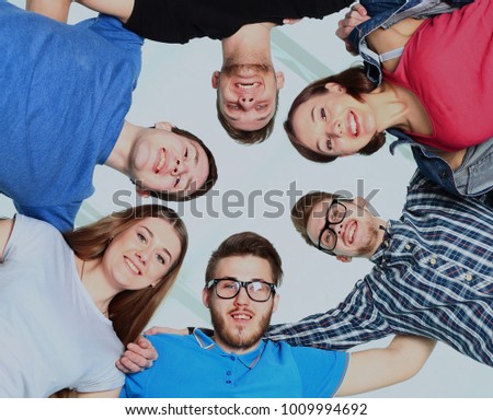 portrait of confident college students forming huddle over white background.