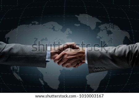 Handshake with map of the world in background.