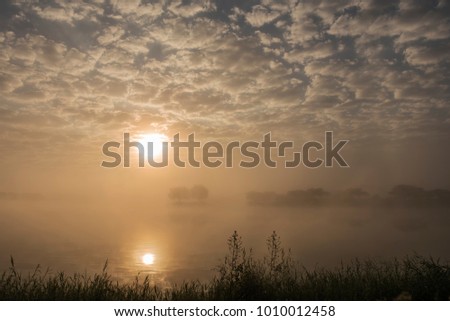The sunny with fluffy clouds and foggy in the morning at the lake