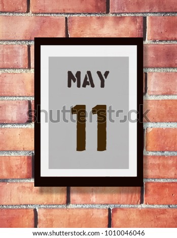 May 11. 11th May calendar on the wood photo frame with brown brick background. Spring day