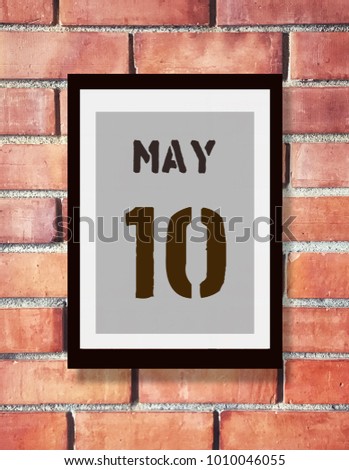May 10th. 10 May calendar on the wood photo frame with brown brick background. Spring day