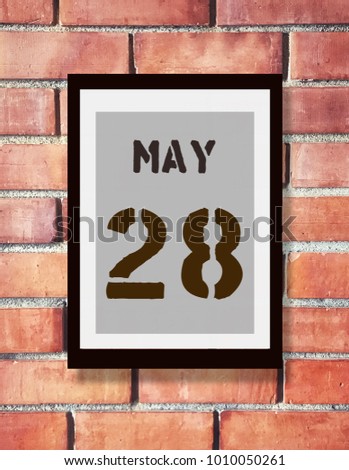 May 28th. 28 May calendar on the wood photo frame with brown brick background. Spring day