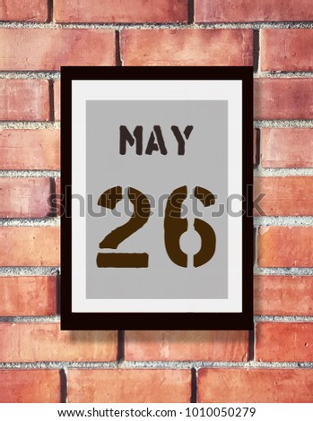 May 26th. 26 May calendar on the wood photo frame with brown brick background. Spring day