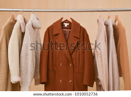 Set of Coat with sweater(t shirts)on a hanger,-wooden  background 
