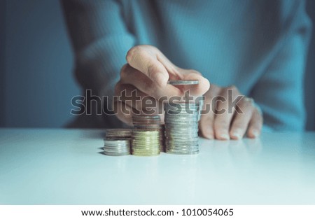 Close up of hand putting coins stacks on a table,Saving money concept