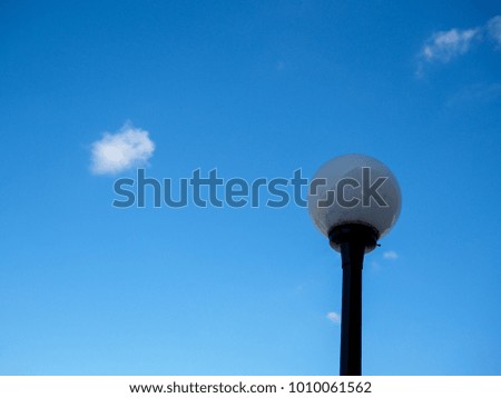 The round glass lamp post with blue sky.