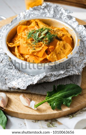 Vegetarian and vegan pumpkin casserole with dill, parsley, onion, garlic and spinach in backing dish. Healthy food concept.