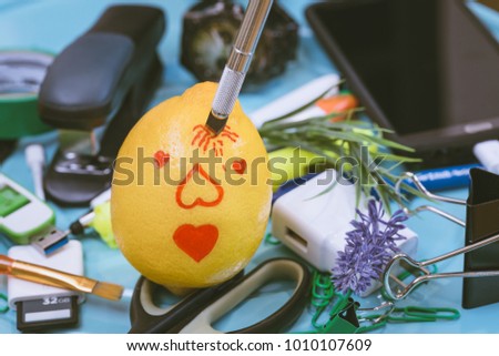 The portrait of Cupid drawn on a lemon in which an office knife is inserted as the metaphor of the victory of feelings against reason. The creative concept is "Devoid of reason at Valentine's Day"