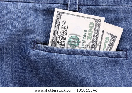 closeup dollars in a jeans pocket