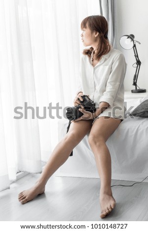 Asian Teenage girl with digital camera on light background at home.