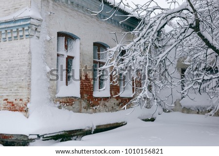Photo of a winter cityscape. Old architecture under deep snowdrifts. Doors and windows.