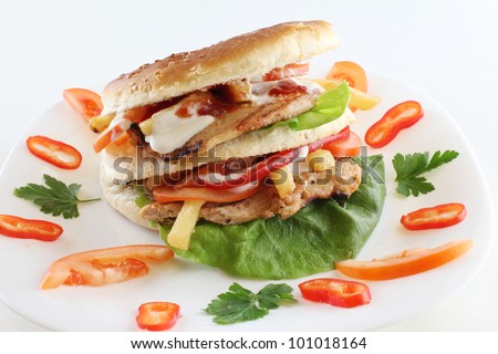 Burger with cheese,lettuce and tomato served on white plate