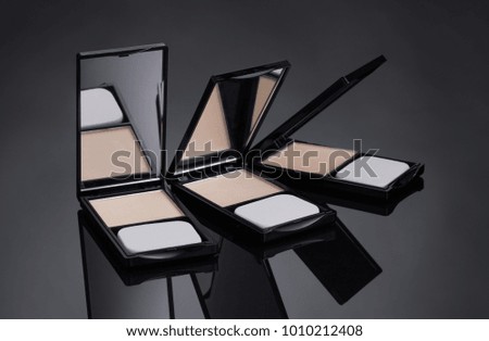 Template for advertising cosmetic decorative means. Black background with three outdoor compacts. The place to insert the text.