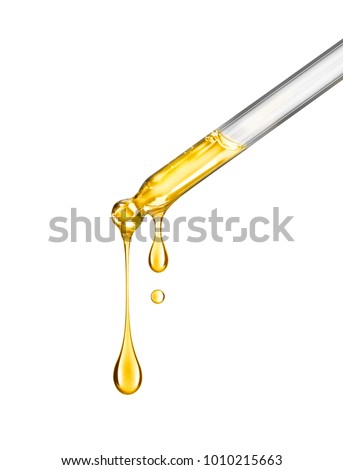 Cosmetic pipette with drops of cosmetic oil close-up on a white background Royalty-Free Stock Photo #1010215663
