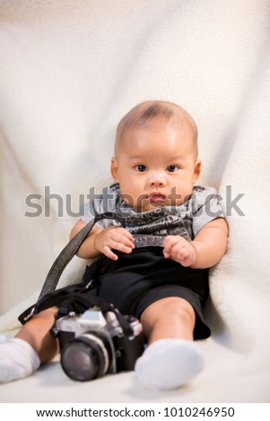 an isolated asian baby holding camera photo