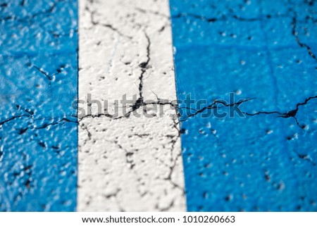 Abstract, blue background of newly made outdoor basketball court in park. Visible asphalt texture, freshly painted lines. 
