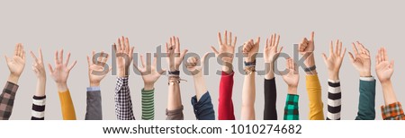 Different colour arms up on gray background Royalty-Free Stock Photo #1010274682