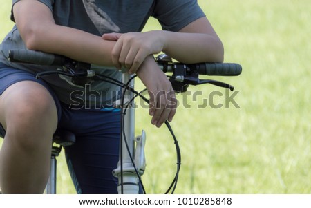 Young men riding bicycles with blurred soft green grass background.  