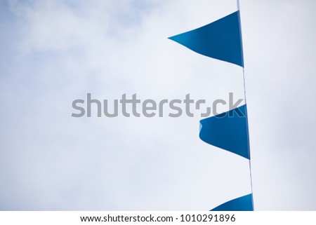 Blue flags against clouds in sky