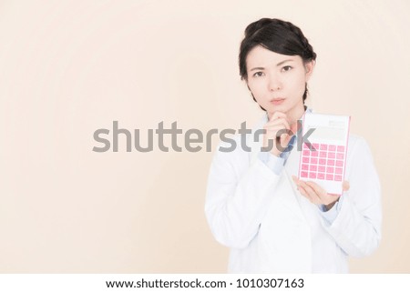 Young woman having an electronic calculator