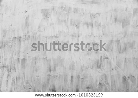 painted surface with visible white paint masks brush, black and white image


