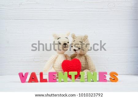Sweet couple teddy bear doll in love with valentine text and red knitting heart on white wooden background and copy space for add text and picture, love and valentine day concept idea.