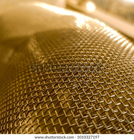 Gold mesh net with focus and shallow depto fo field, gold bokeh net pattern