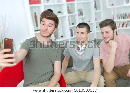 teenagers taking selfie with mobile phone in the living room