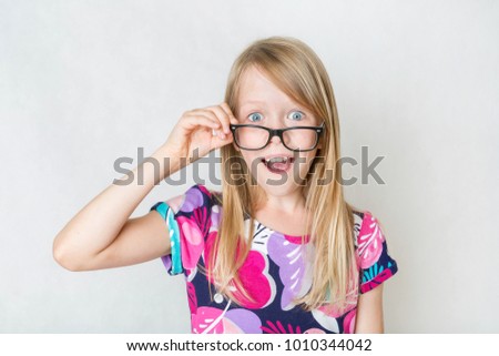 Surprised girl looking above black glasses