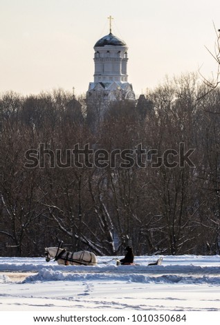 Man in the cart with a white horse on background of Russian church. winter landscapes in Moscow. 