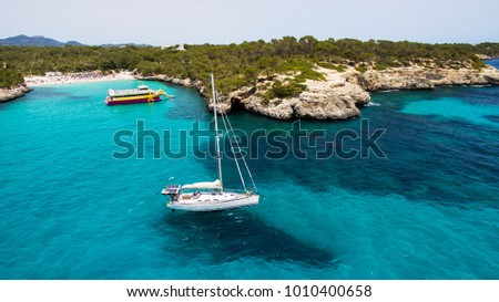 The boat sails near the beautiful beach in north Mallorca, Spain, Balearic islands, Aerial/drone photo