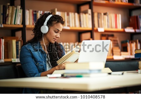 Young female student study in the school library.She using laptop and learning online.