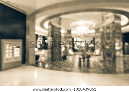 Blurred luxury lobby interior, digital signage board, marble pillars. Vintage look